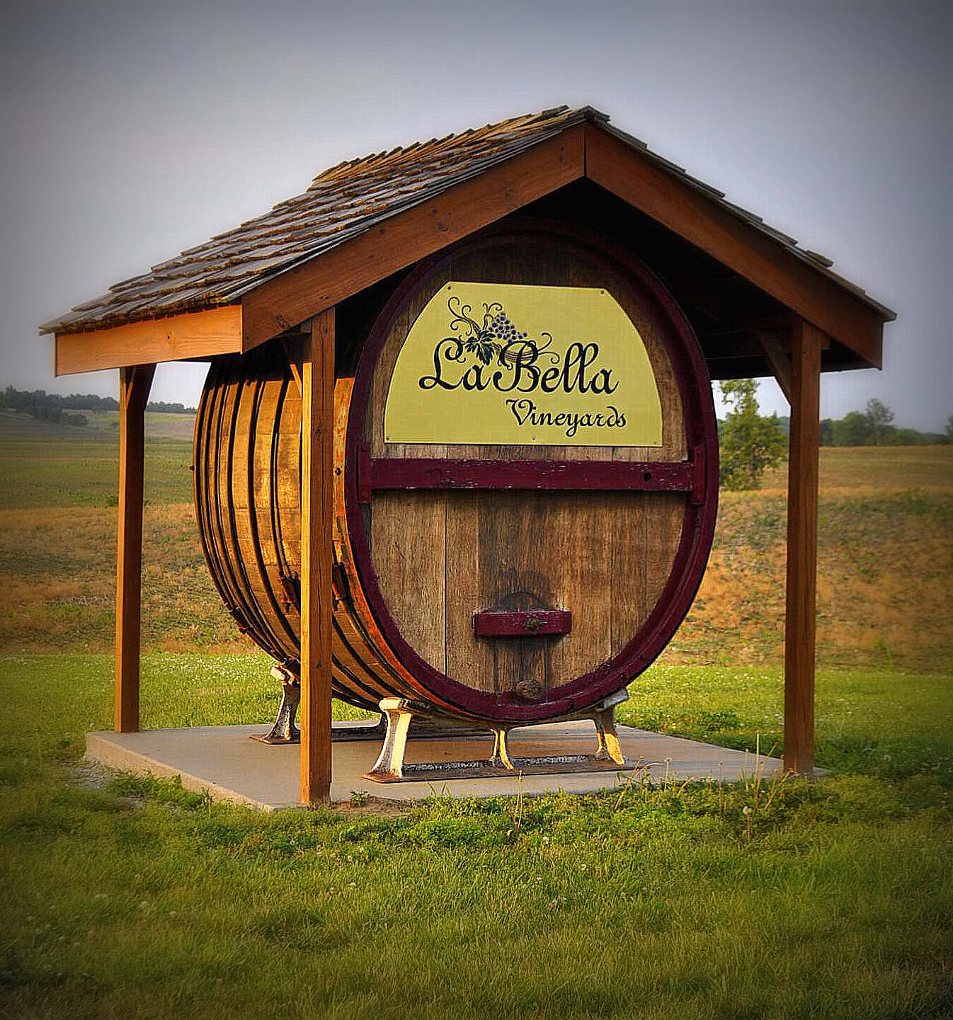 La Bella Vineyards & Winery - outdoor photo, daytime, of a large wine barrel with the vineyard logo underneath a gazebo-style roof.