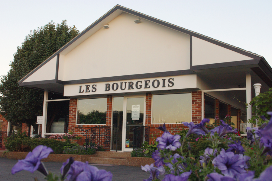 Les Bourgeois Vineyards- Outdoor image of the winery's tasting room. It is a brick and white building.