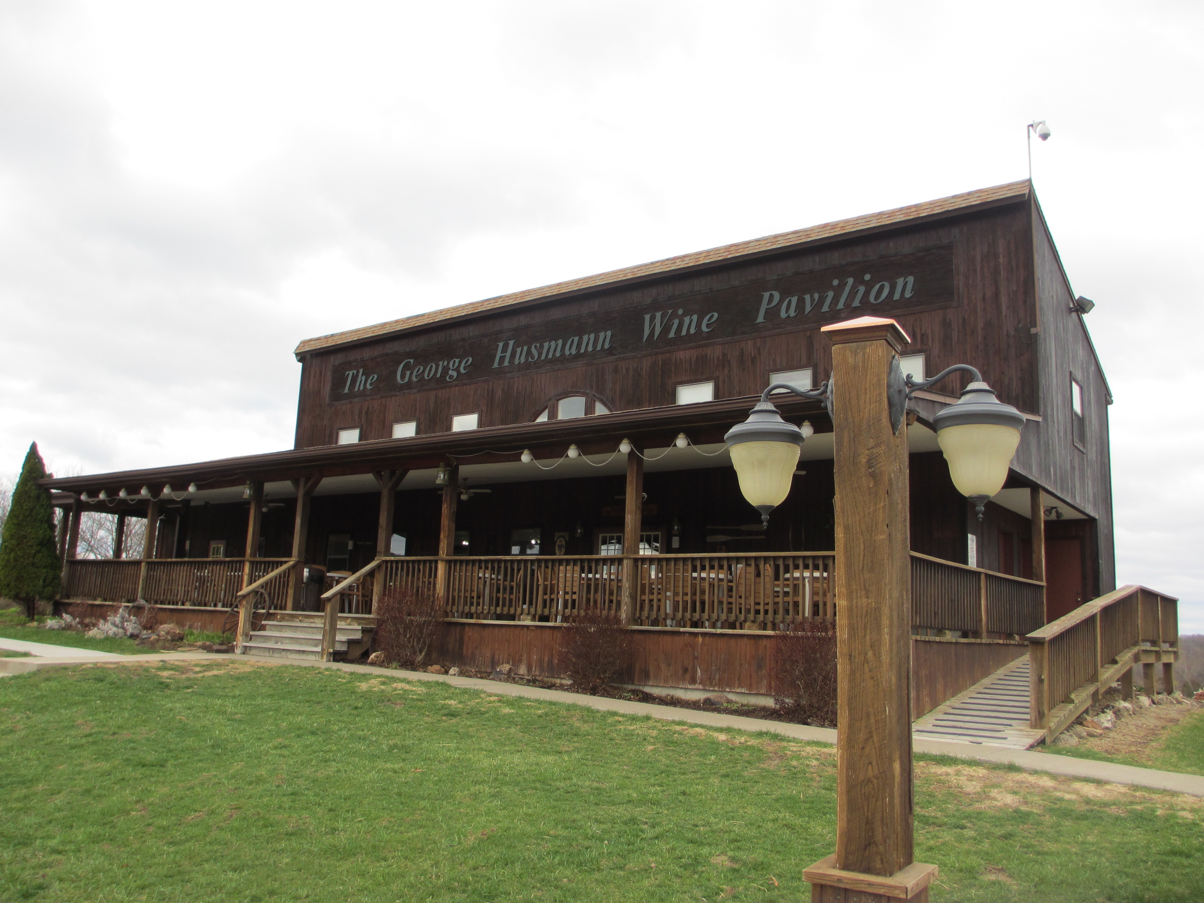 Oak Glenn Winery LLC- A brown wooden building with a large deck. The sign on the building reads "The George Husmann Wine Pavilion".