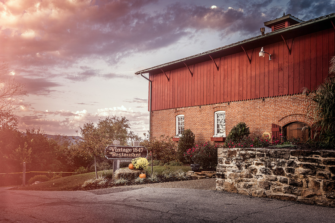 Stone Hill Winery - outdoor photo, daytime, an exterior photo of a large red building with a cloudy sky in the background.
