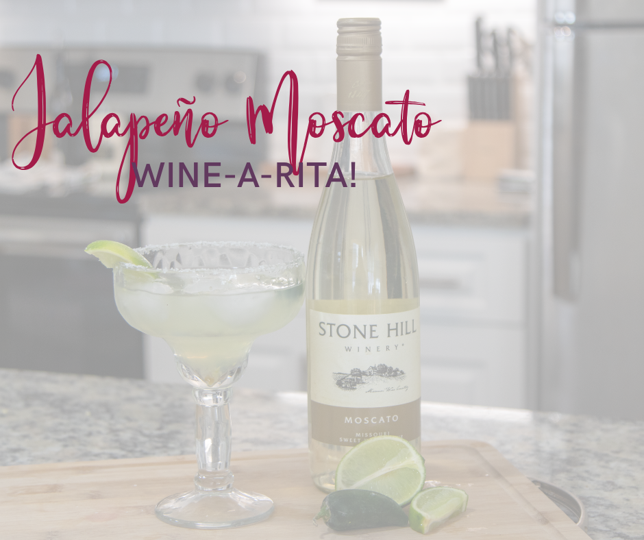 Margarita glass filled with a wine-a-rita with a bottle of stone hill wine sitting next to it with a lime and jalapeño on the cutting board in front. There is text over the top of the image that reads Jalapeño Moscato Wine-A-Rita!