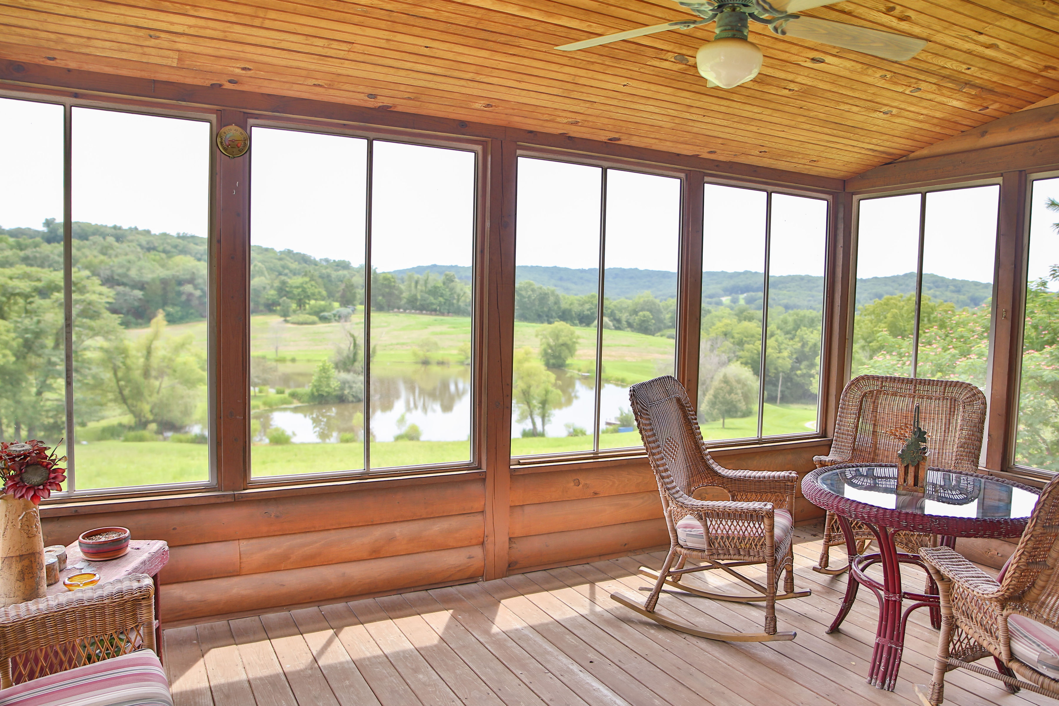 Adam Puchta Winery- A screened in porch with tables and rocking chair seating