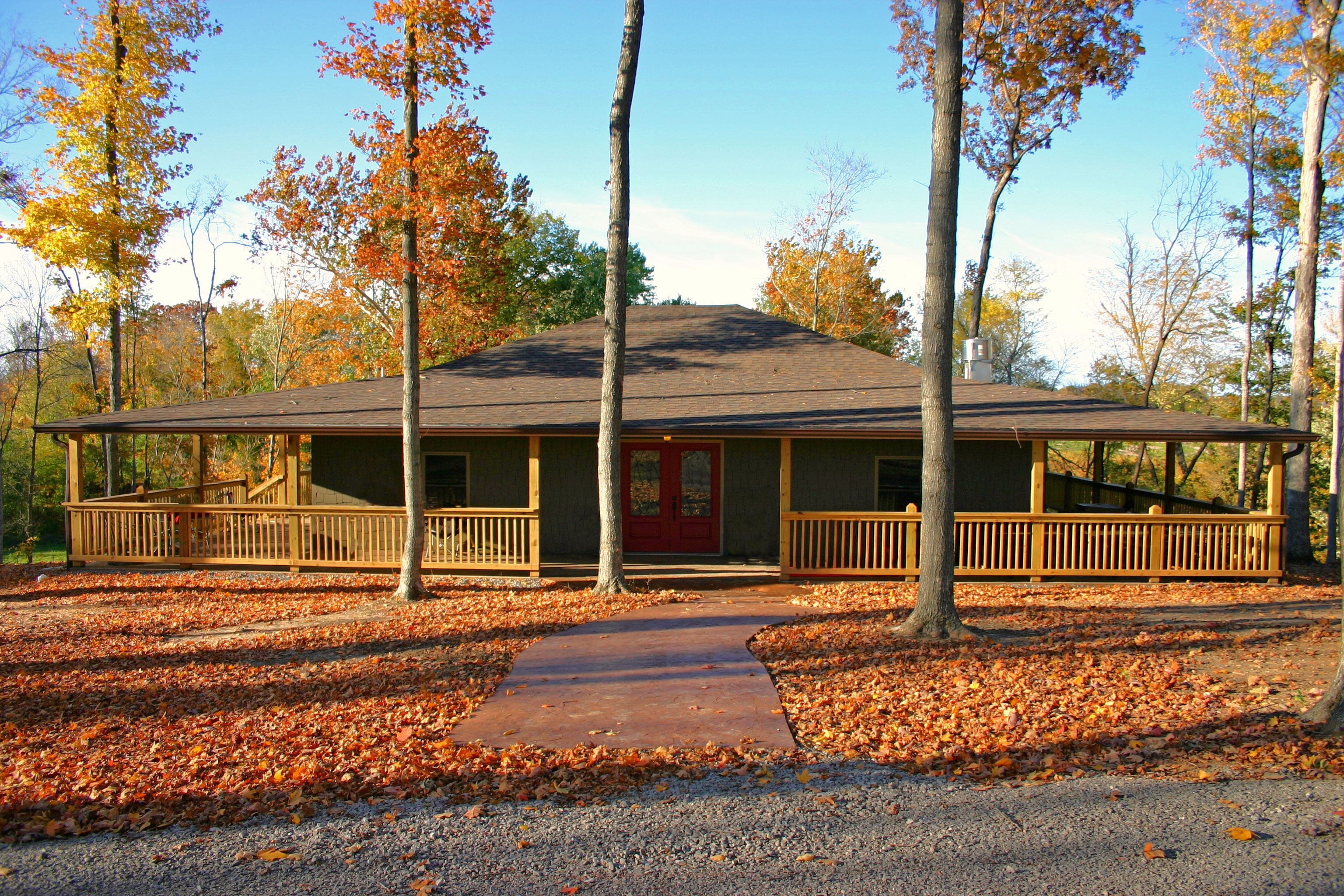 Apple Creek Vineyard & Winery - outdoor photo, daytime, of a large cabin with trees and a walkway surrounded by fallen leaves.