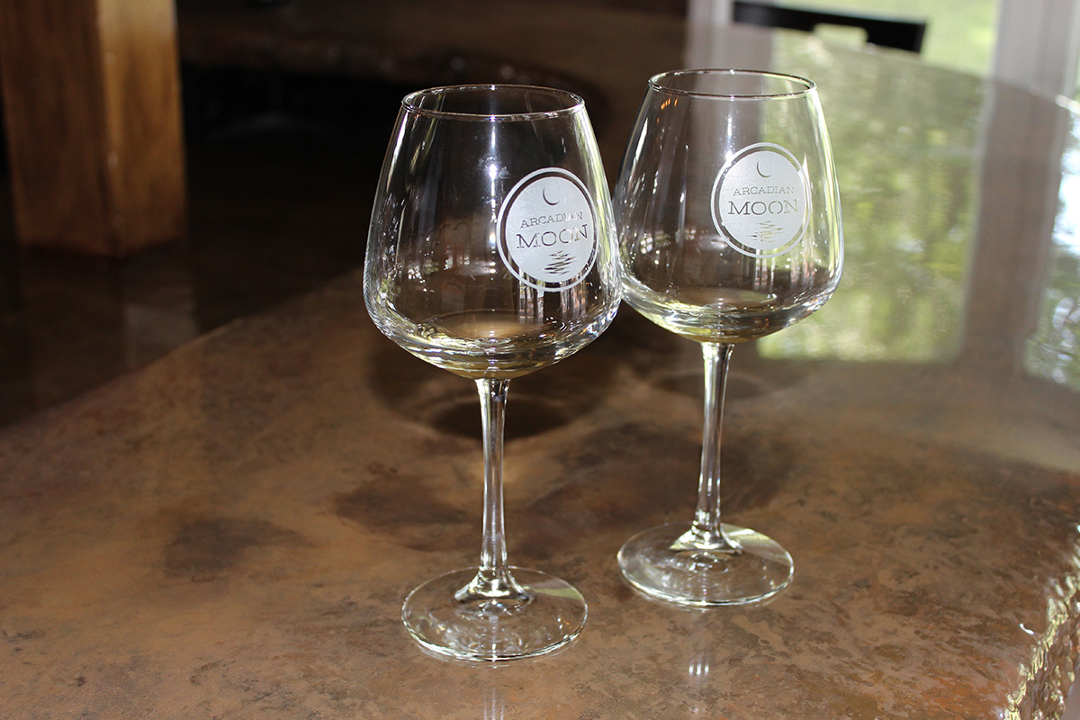 Arcadian Moon Winery & Brewery- Two custom glasses of wine with a small amount of white wine.