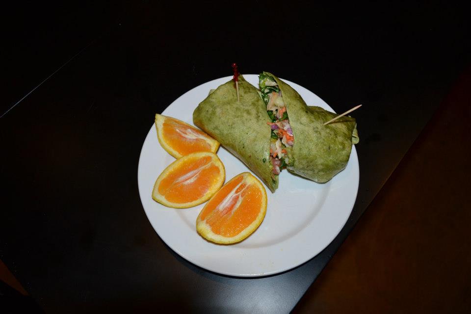 Belmont Vineyards - indoor photo, a white plate with oranges and a wrap-type item made of a green tortilla and filled with a filling.