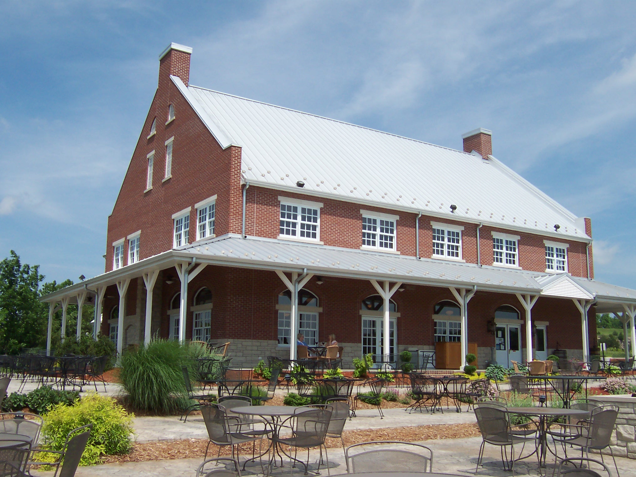 Canterbury Hill Winery and Restaurant - outdoor photo, daytime, of a large building with a white roof. A patio area is visible in the foreground.