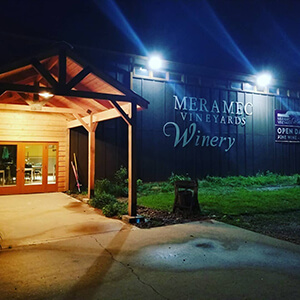 Meramec Vineyards Winery - outdoor photo, nighttime, of the main vineyard building with the entrance area lit by overhead lighting.
