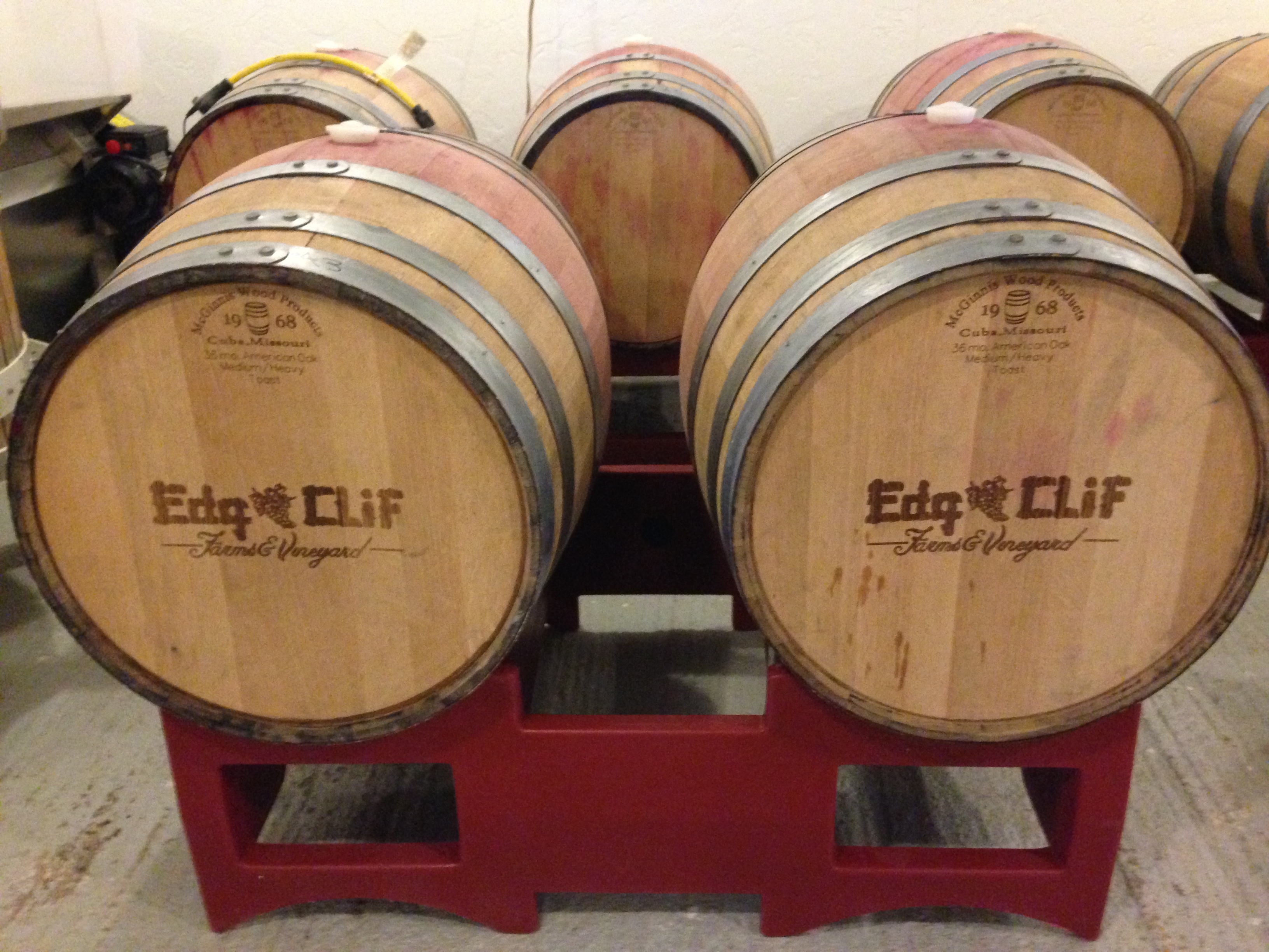 Edg-Clif Farms & Vineyard - indoor photo of several wine barrels with the winery logo on the front.