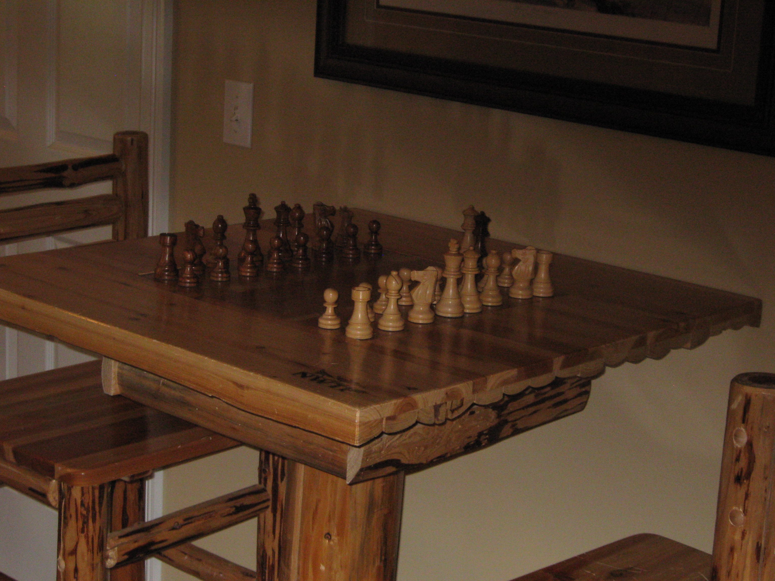 Hummingbird Vineyard and Winery- Wooden chess table with two chairs.