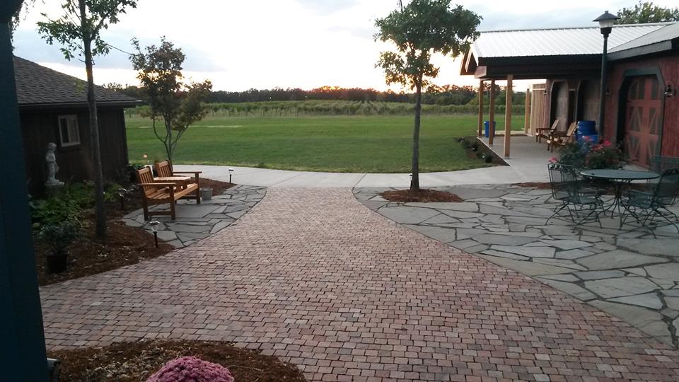 LaChance Vineyards - outdoor photo, daytime, of the interior of a cobblestone courtyard with trees and buildings visible.