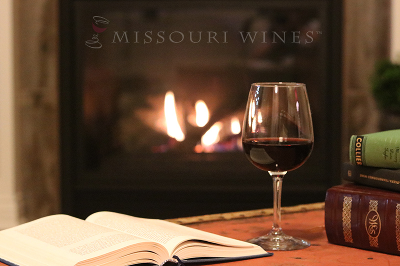 Missouri red wine and book in front of a fire.