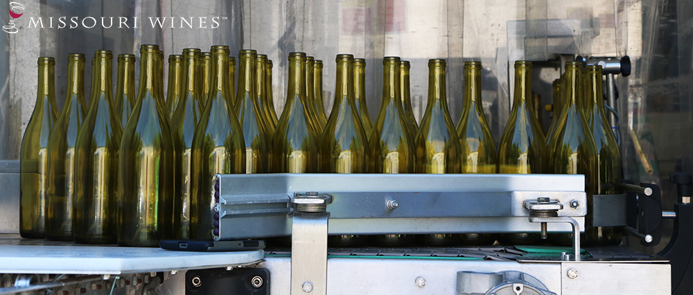 Old Woolam Custom Bottling - Bottles lined up on their way to be filled.