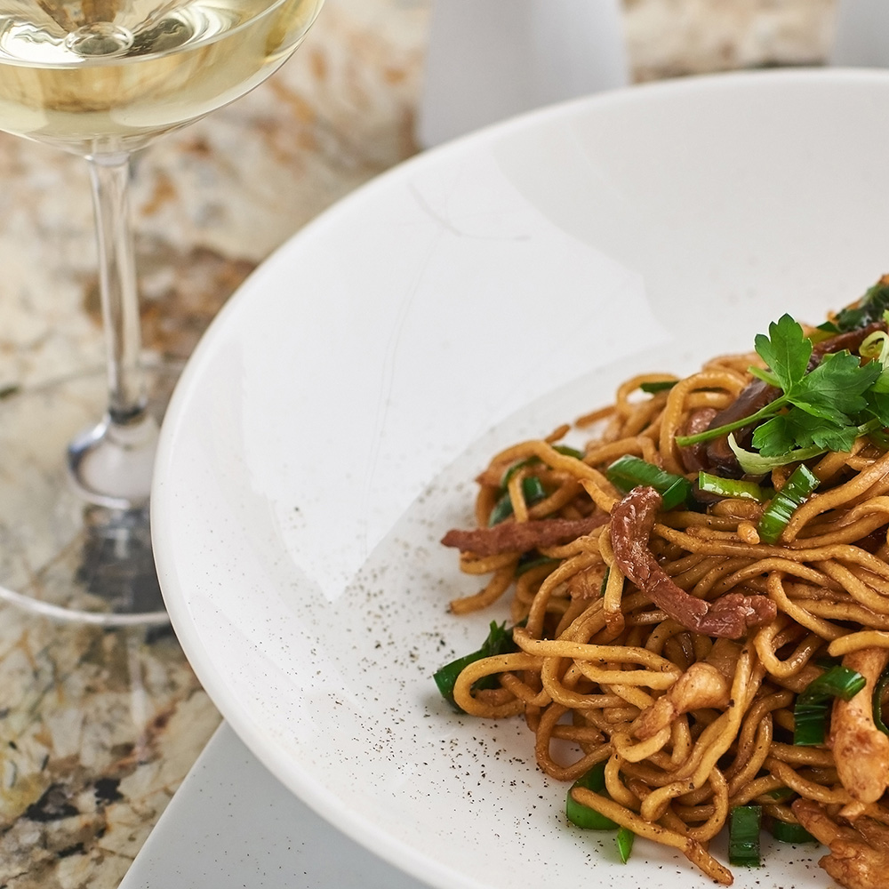 Sweet Cuts Heat, But Why? Spicy noodles alongside a glass of white wine