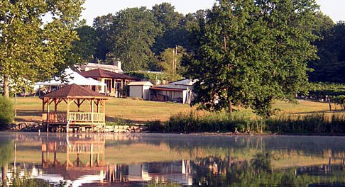 Villa Antonio Winery- A gazebo out on a lake in front of a few small buildings.