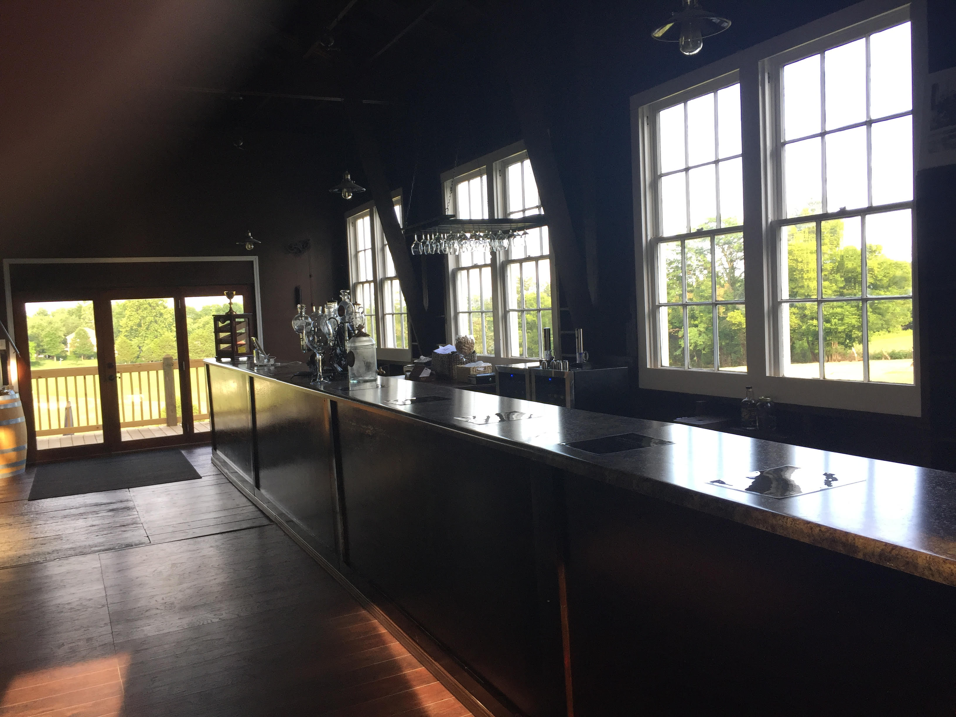 Holy Grail Winery & Vineyard- Indoor bar with several white trimmed windows behind