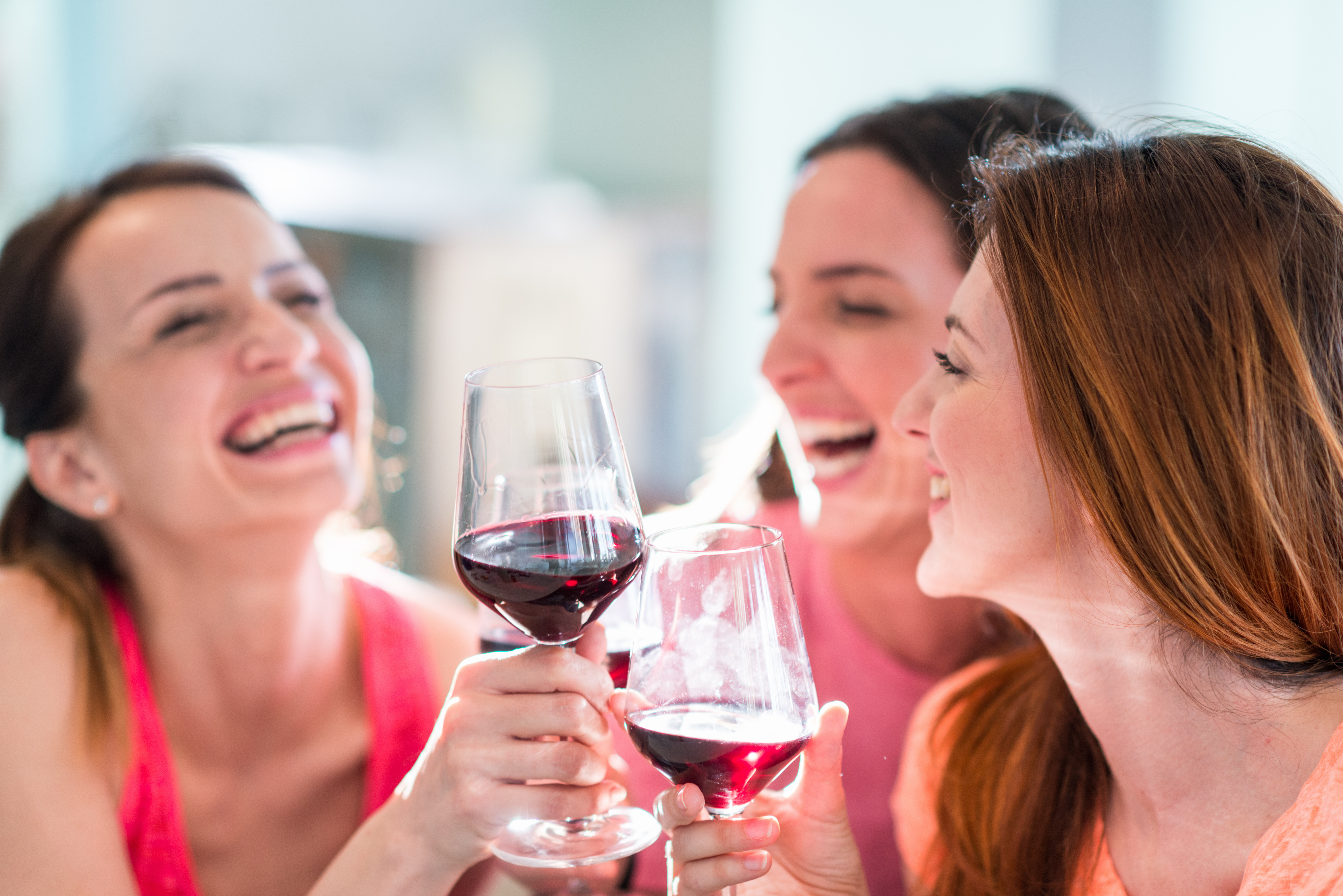 Girls laughing with wine in hand