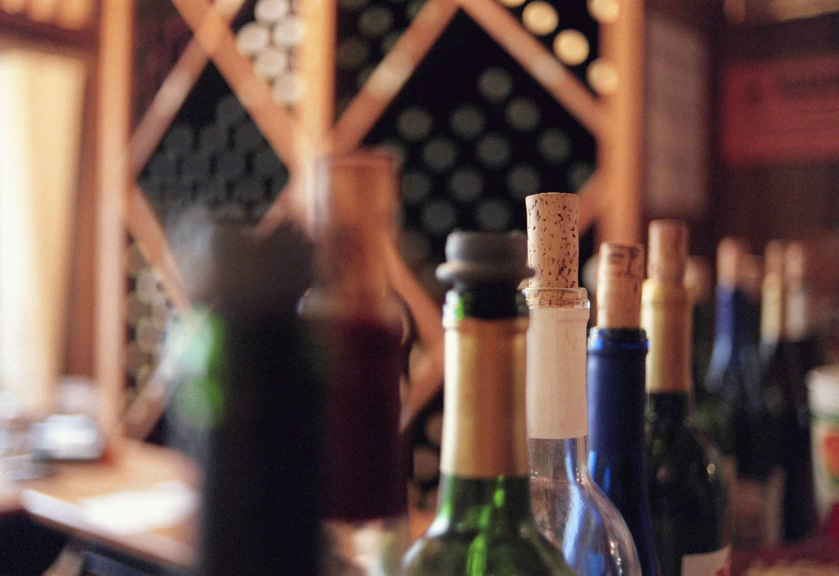 Picture of multiple wine bottles with open corks