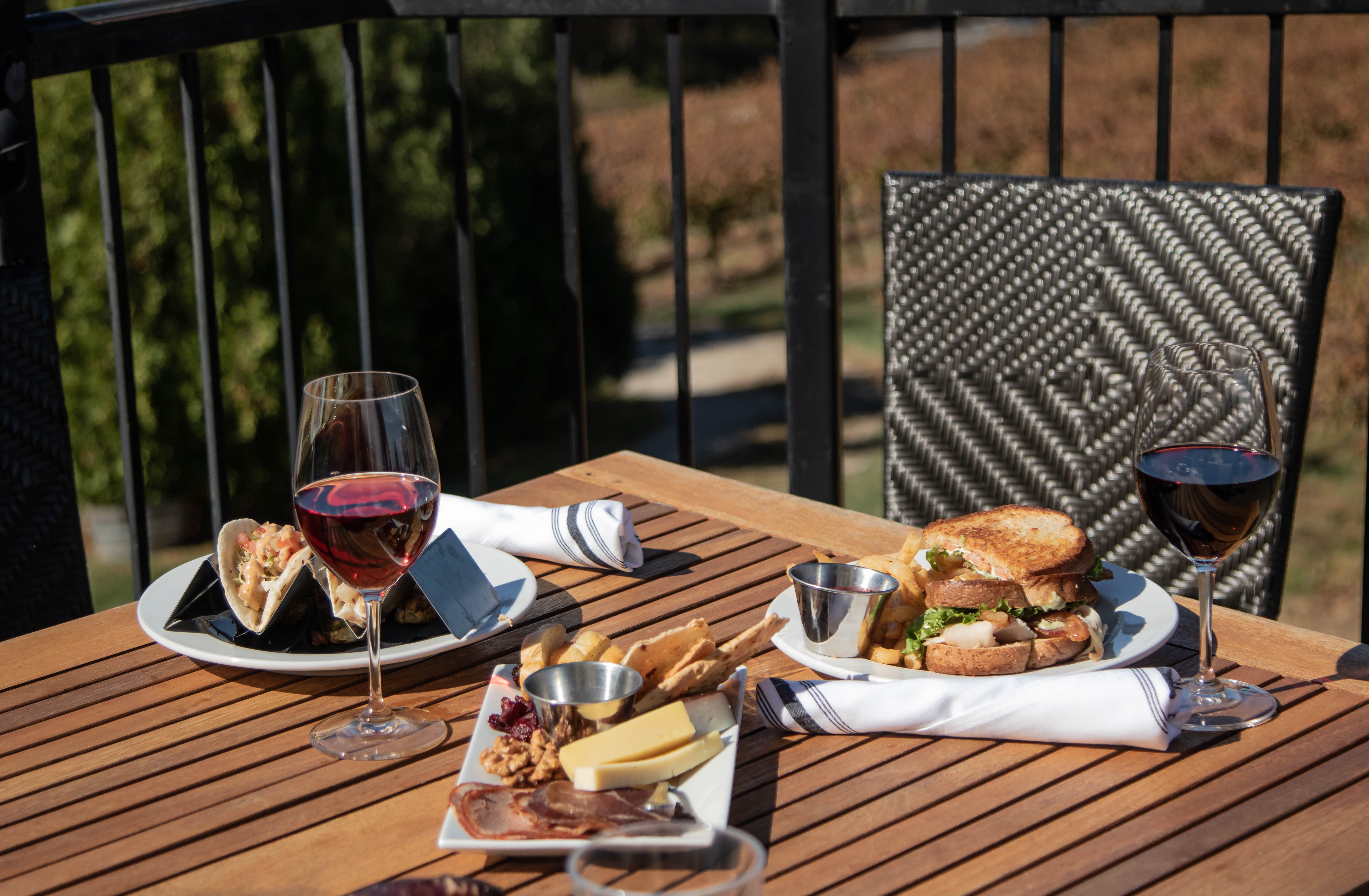 Food and wine sitting on a table with a chair in the background