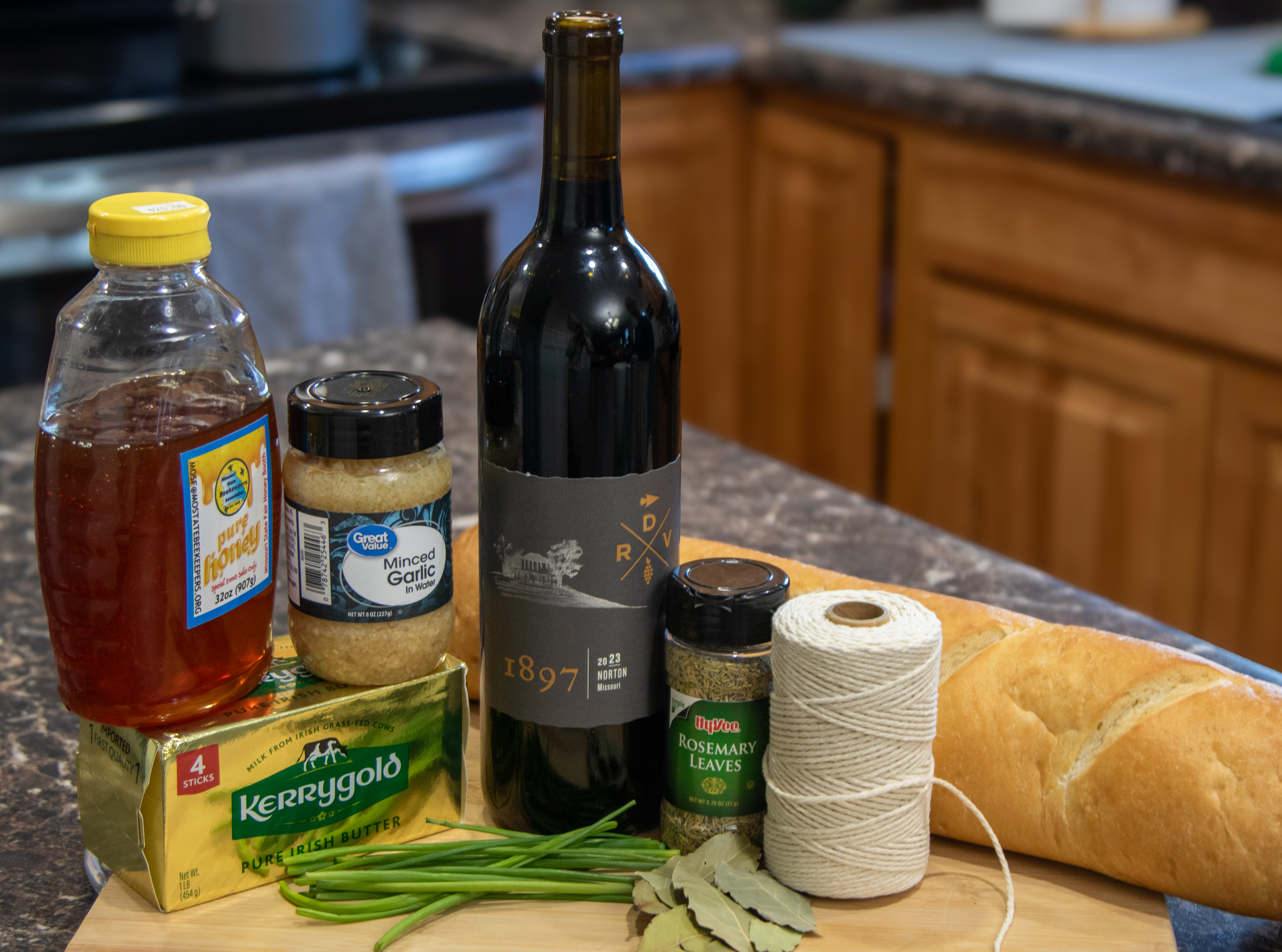 Ingredients:   1 cup Norton   1 sprig rosemary   1 bay leaf  ½ tsp. honey   1 cup butter, softened to room temperature  1 clove garlic, minced   Kosher salt   Ground black pepper  Kitchen twine  2 Tbsp. chopped chives