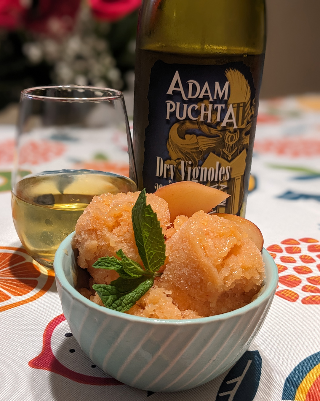 Granita in a bowl with a glass of wine next to it