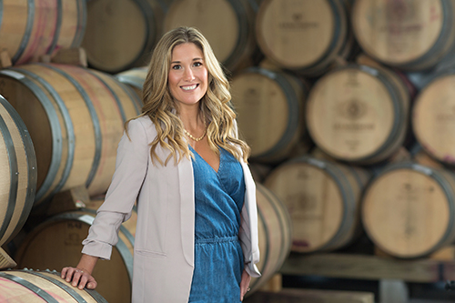 Headshot of Rachel Holman in front of wine barrels