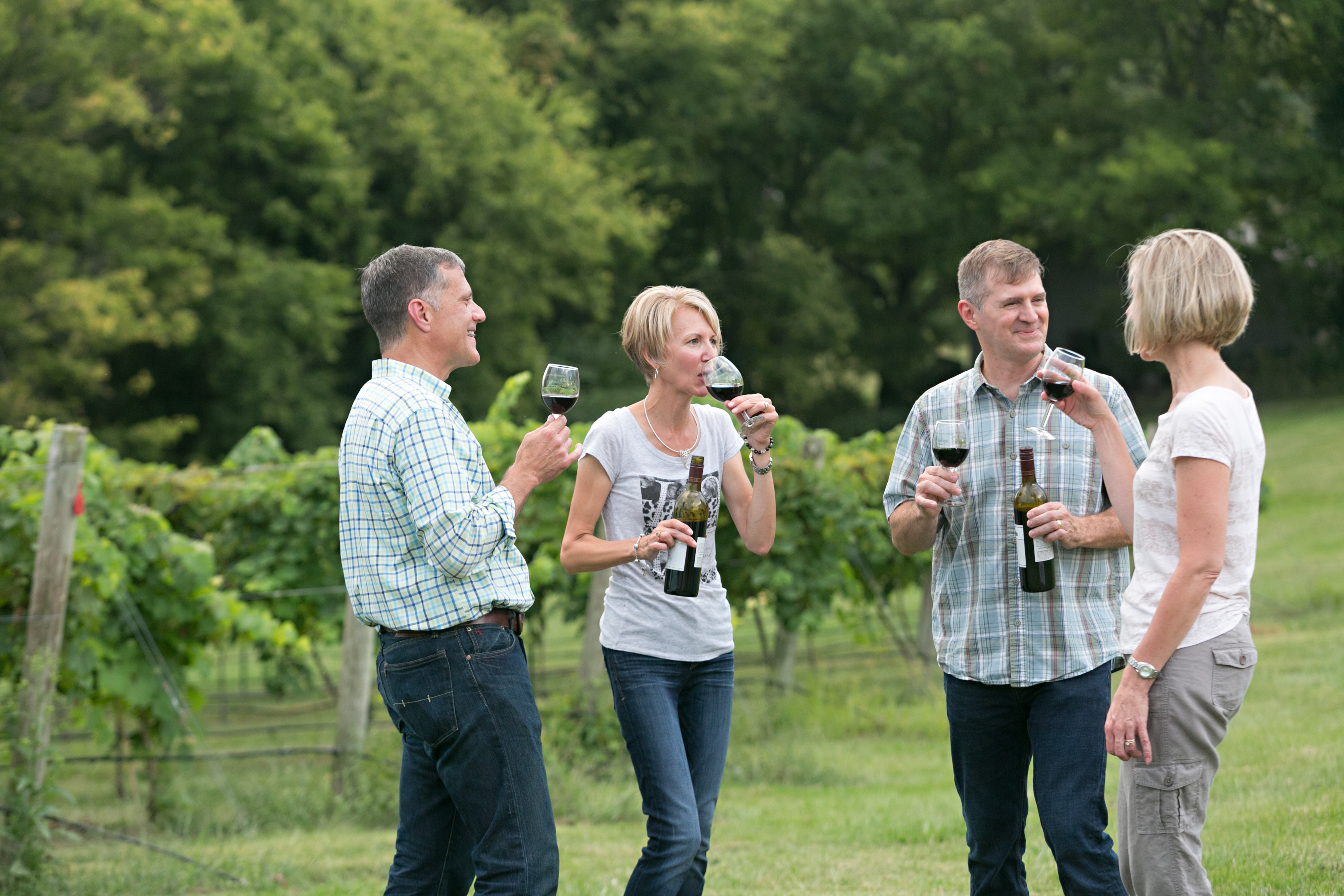 Group walking and sipping in vineyard