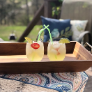 2 glasses of pineapple joy sitting on a deck