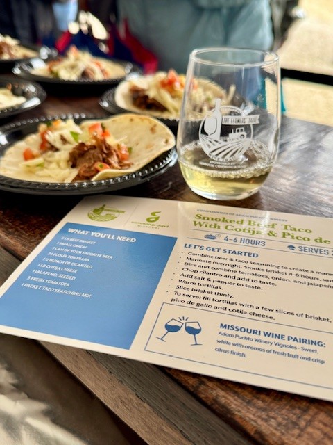 Tacos plated with a glass of wine next to it with a recipe card