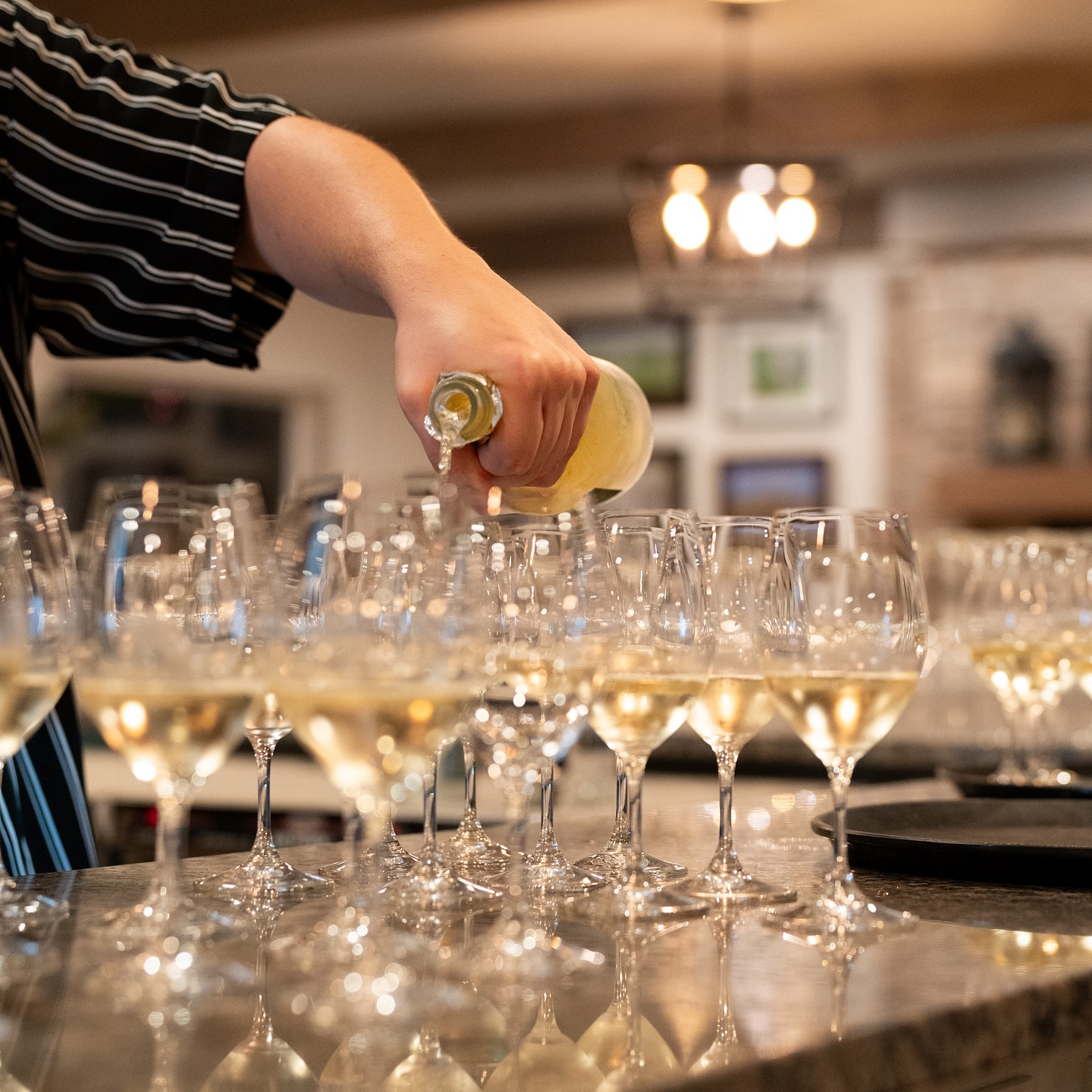wine being poured into several glasses