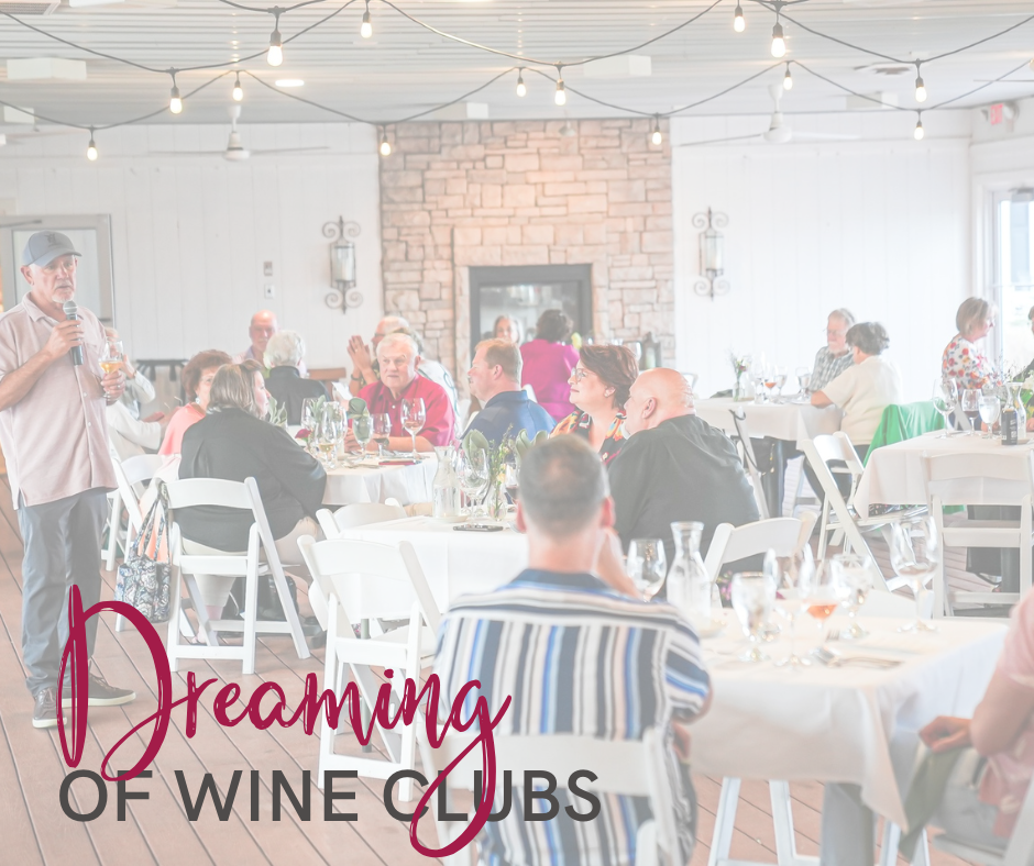 Crowd seated at wine event with round tables in front of fireplace with text over the top stating "Dreaming of Wine Clubs"